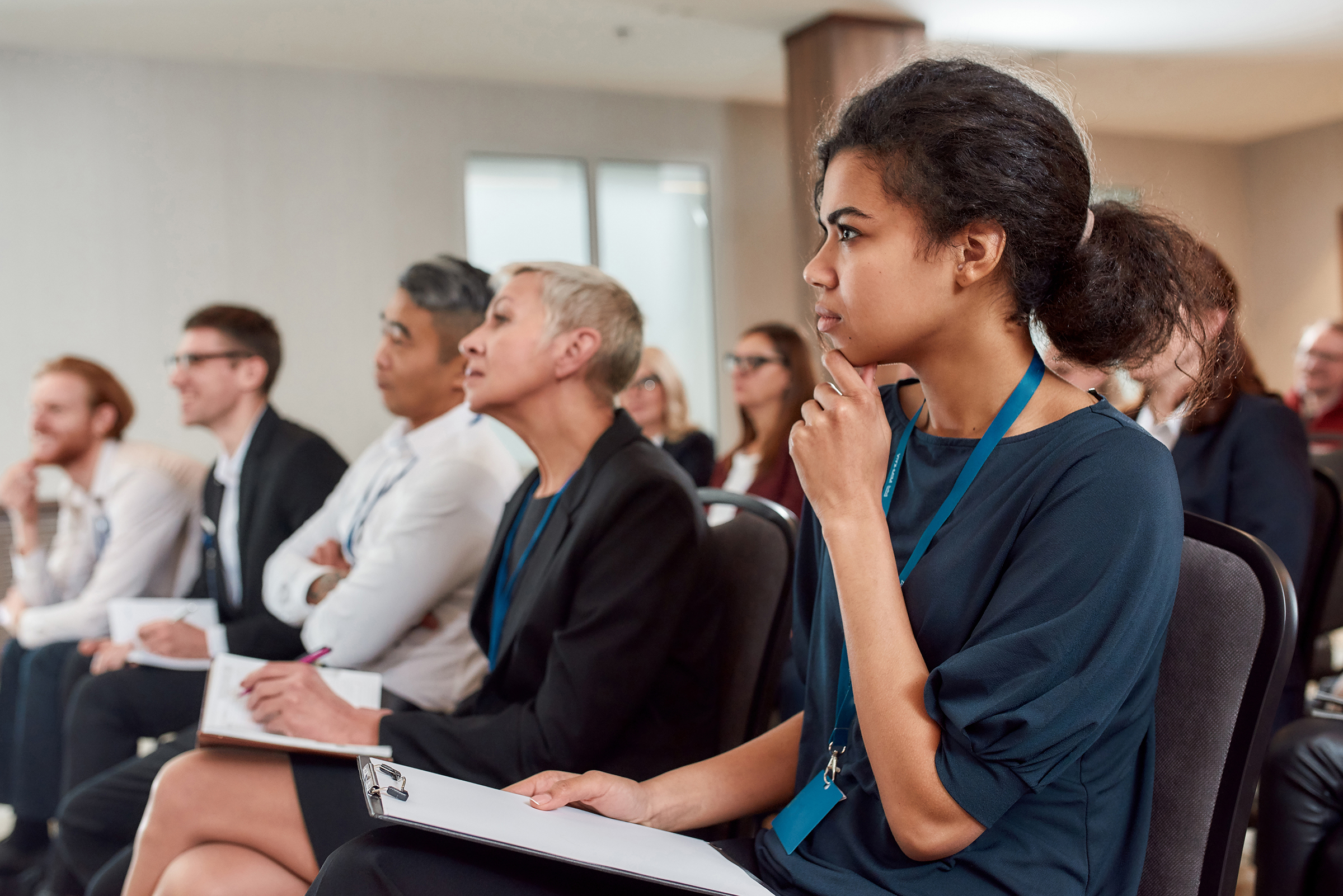 multi-racial men and women seated and listening intently