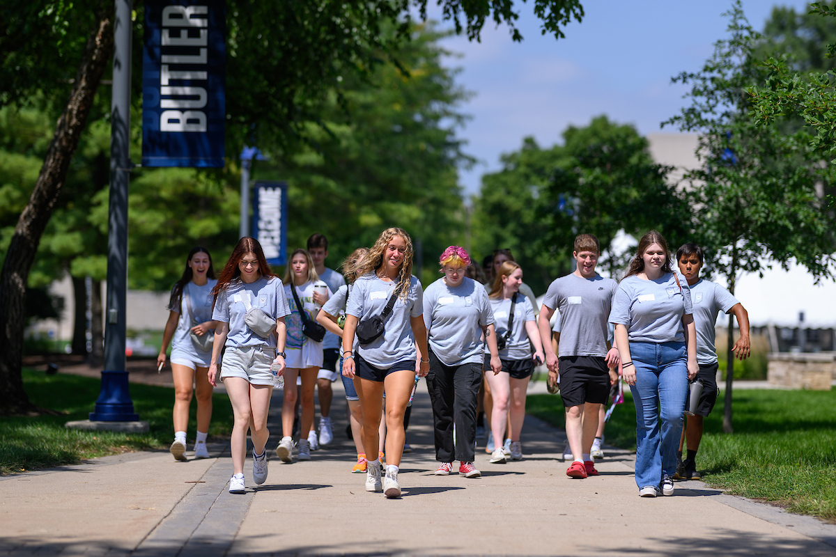 A group of students walks across campus together.